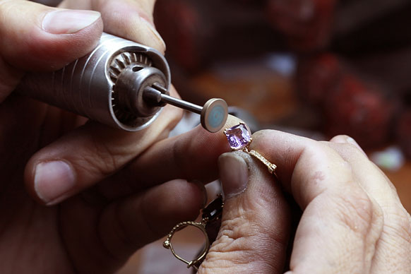 jeweler using a rotary tool and polishing wheel