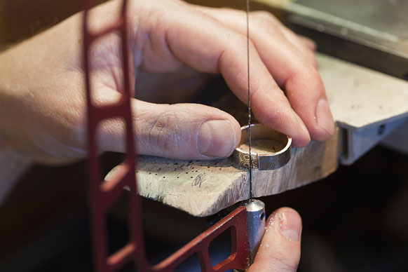 sawing a ring with a jeweler's saw